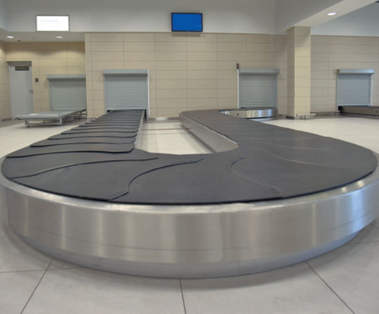 Personale aeroportuale che coordina le operazioni di movimentazione bagagli in pista