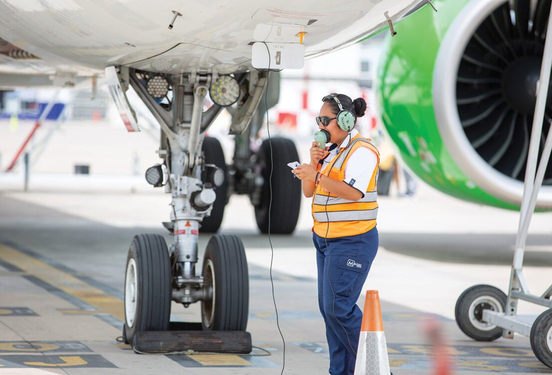 Aeromobile charter in pista con personale di terra al lavoro