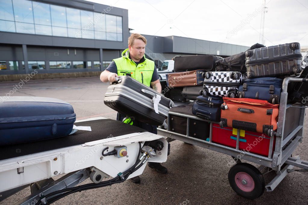 Personale che carica bagagli nella stiva di un aeromobile